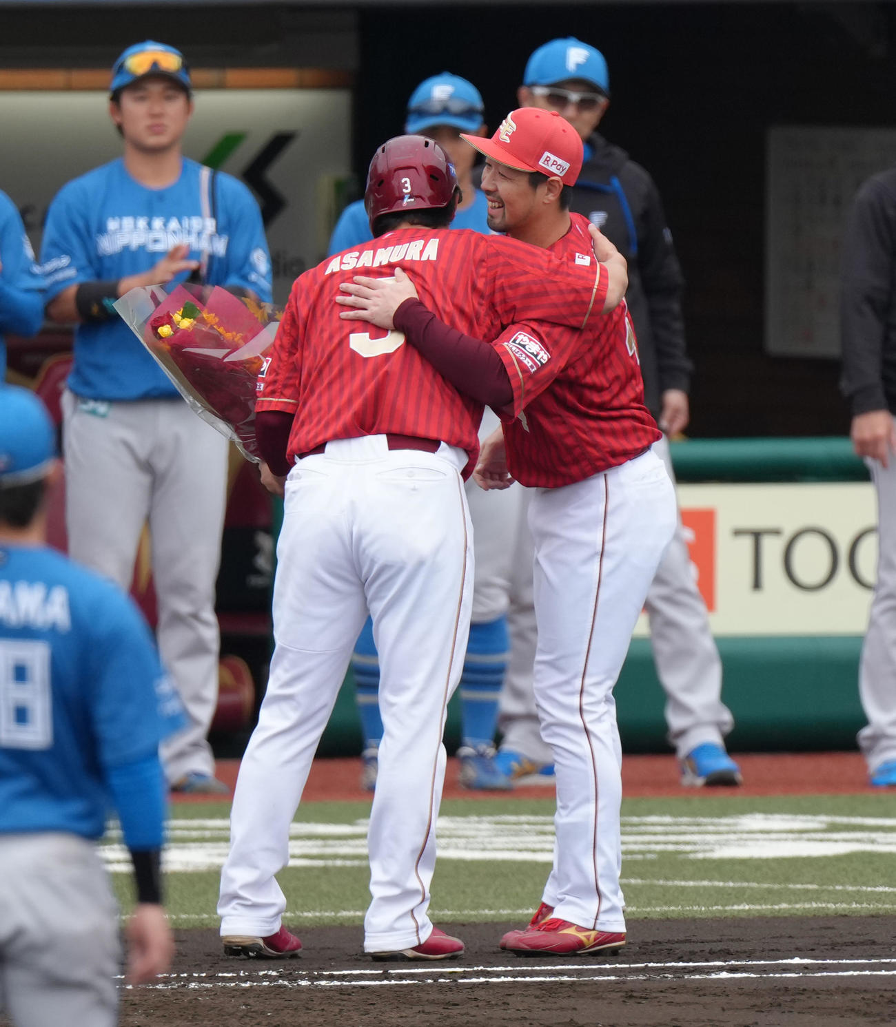 楽天対日本ハム　1回裏楽天1死二塁、浅村（左）は通算2000安打となる右前適時打を放ち阿部から花束を受け取る（撮影・足立雅史）