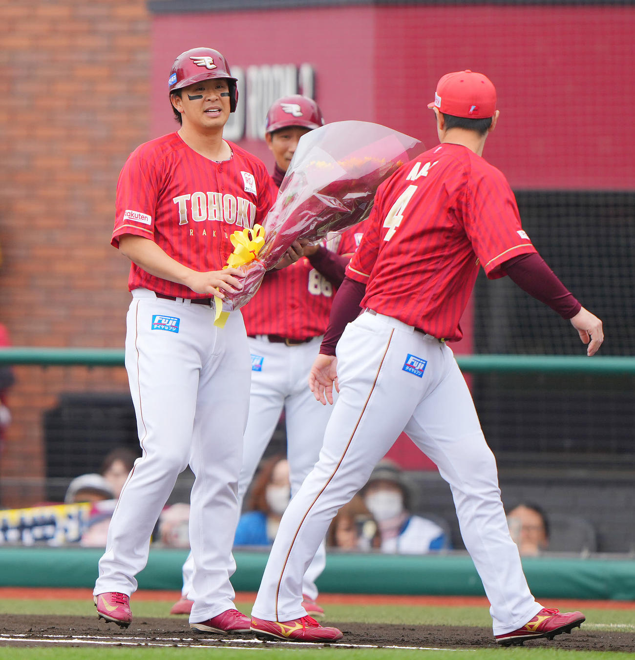 楽天対日本ハム　1回裏楽天1死二塁、通算2000安打となる先制適時打を放ち阿部（右）から花束を受け取り笑顔を見せる浅村（撮影・垰建太）