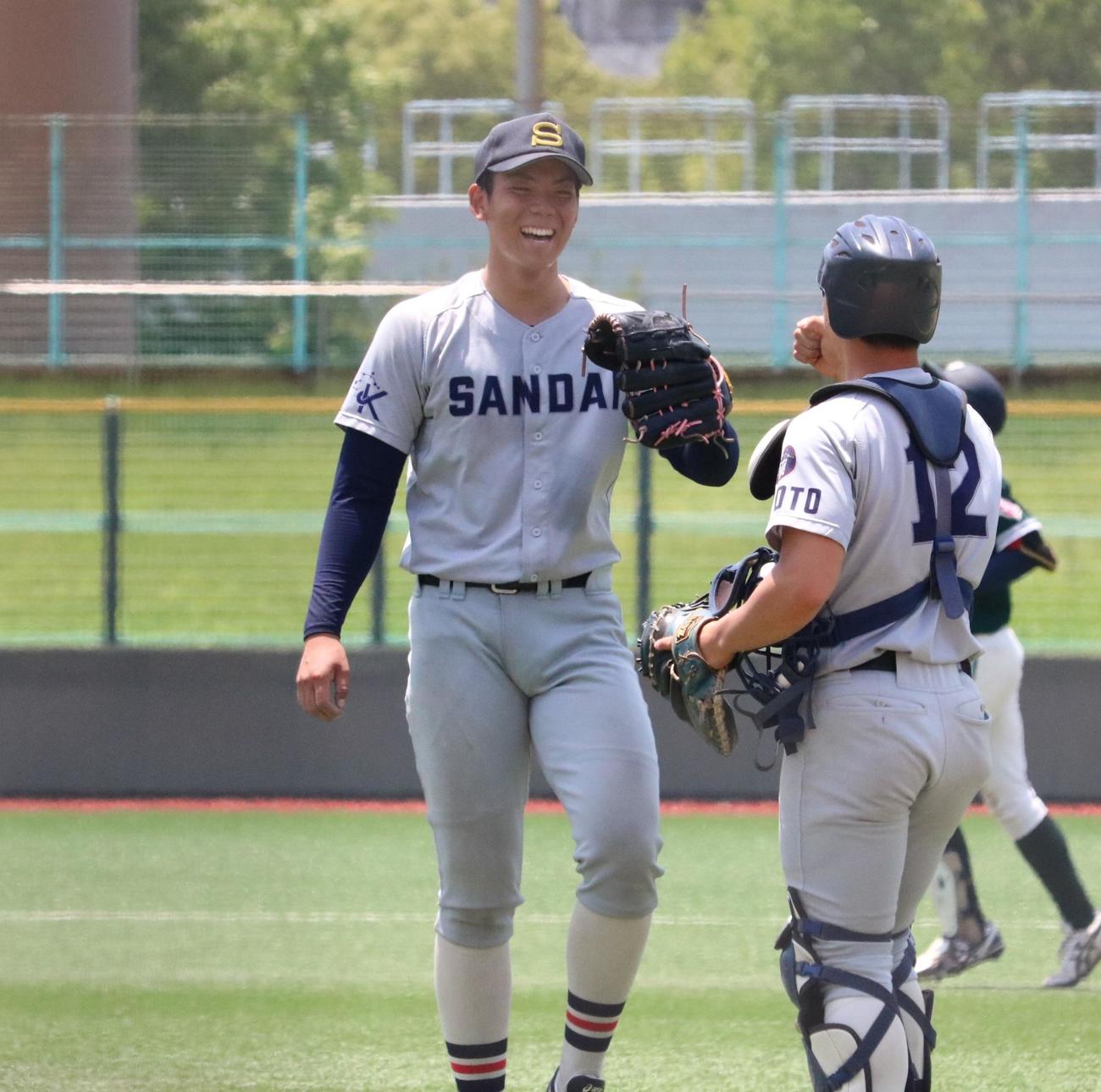 京産大の由上が初完封勝利して捕手と笑顔でタッチを交わす（撮影・林亮佑）