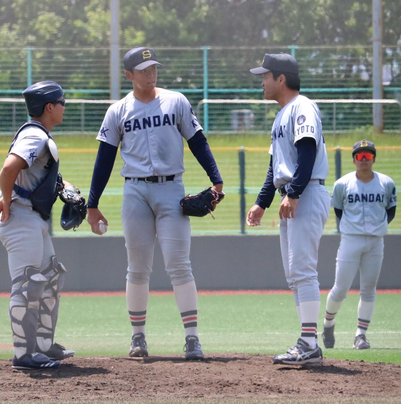 京産大の由上と炭山監督がマウンドで会話する（撮影・林亮佑）
