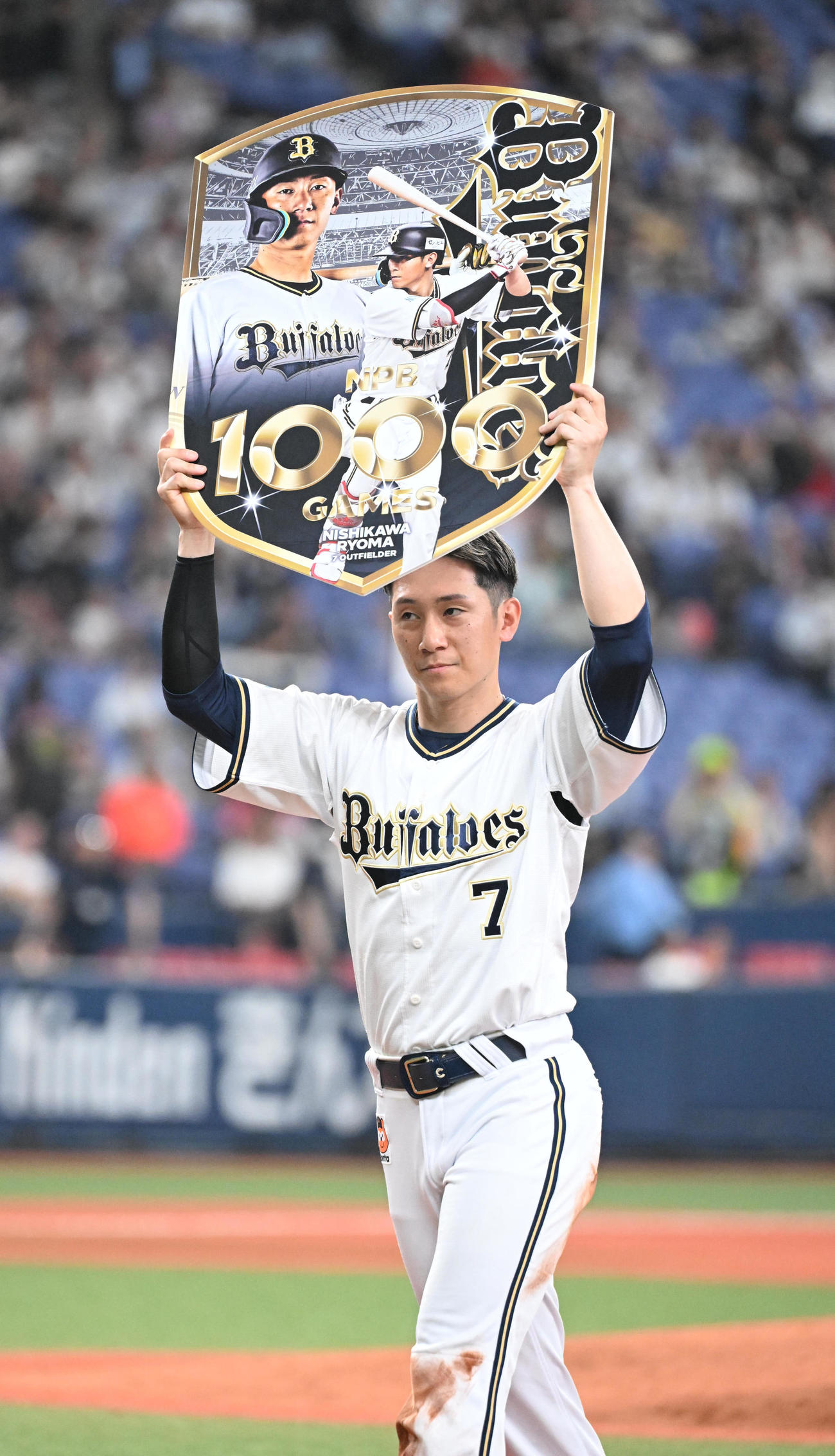 オリックス対ロッテ　5回終了後、1000試合出場を達成したオリックス西川はボードを掲げる（撮影・和賀正仁）