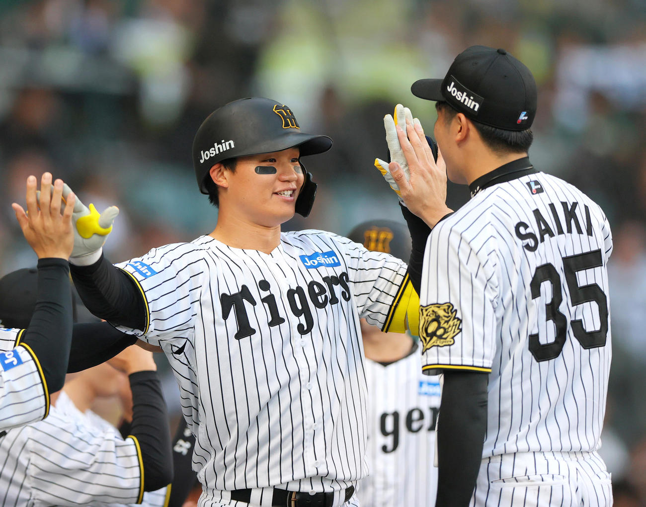 阪神対巨人　1回裏阪神1死一塁、森下（左）は左越え満塁本塁打を放ち才木とタッチをかわす（撮影・上山淳一）