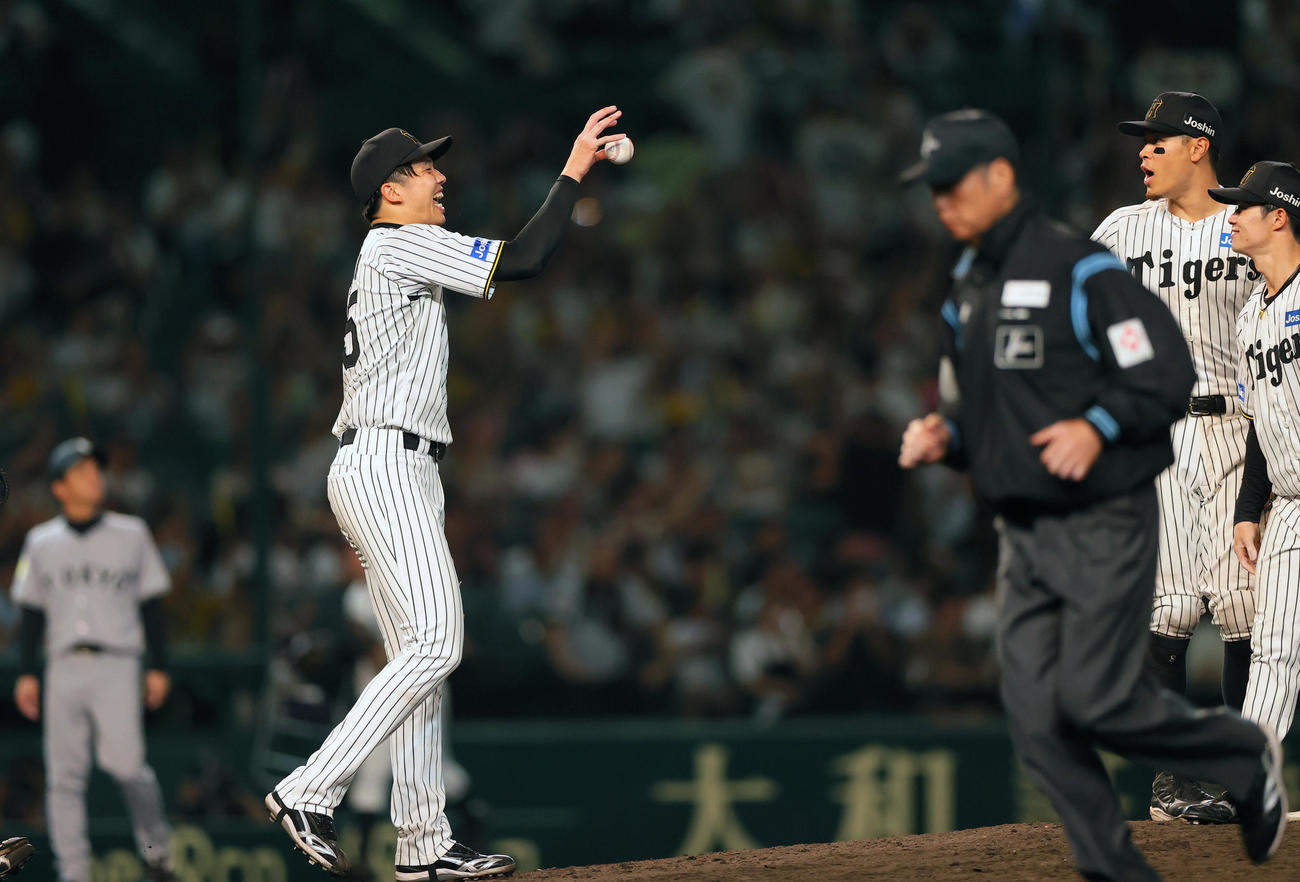 阪神対巨人　9回表巨人2死一、二塁、才木（左）は巨人打線を5安打完封で勝利しウイニングボールを受け取る（撮影・上山淳一）