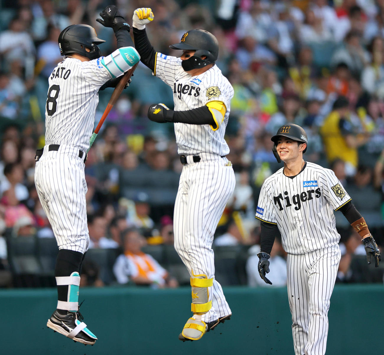 阪神対巨人　1回裏阪神1死一塁、森下（中央）は左越え2点本塁打を放ち佐藤輝とジャンプしてタッチをかわす。右は中野（撮影・上山淳一）