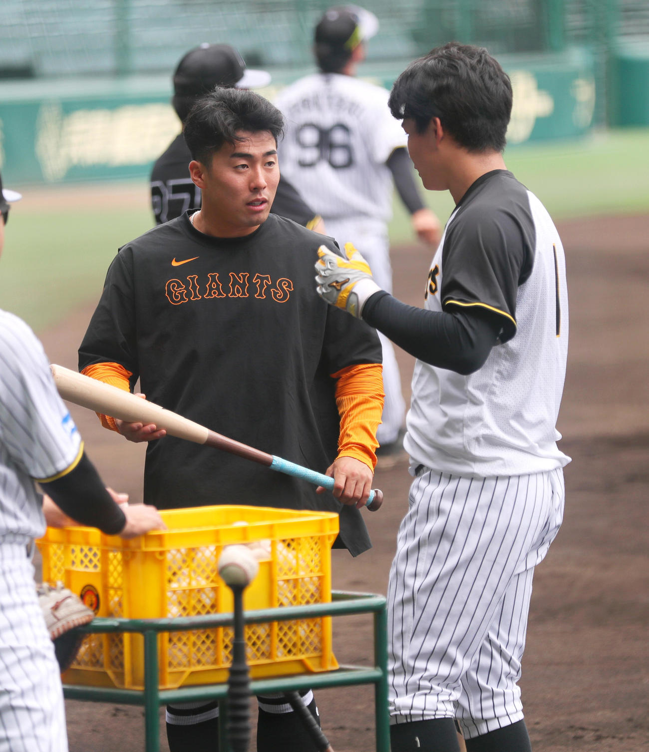 阪神対巨人　試合前、巨人浅野（左）は阪神森下からバットをもらう（撮影・上山淳一）