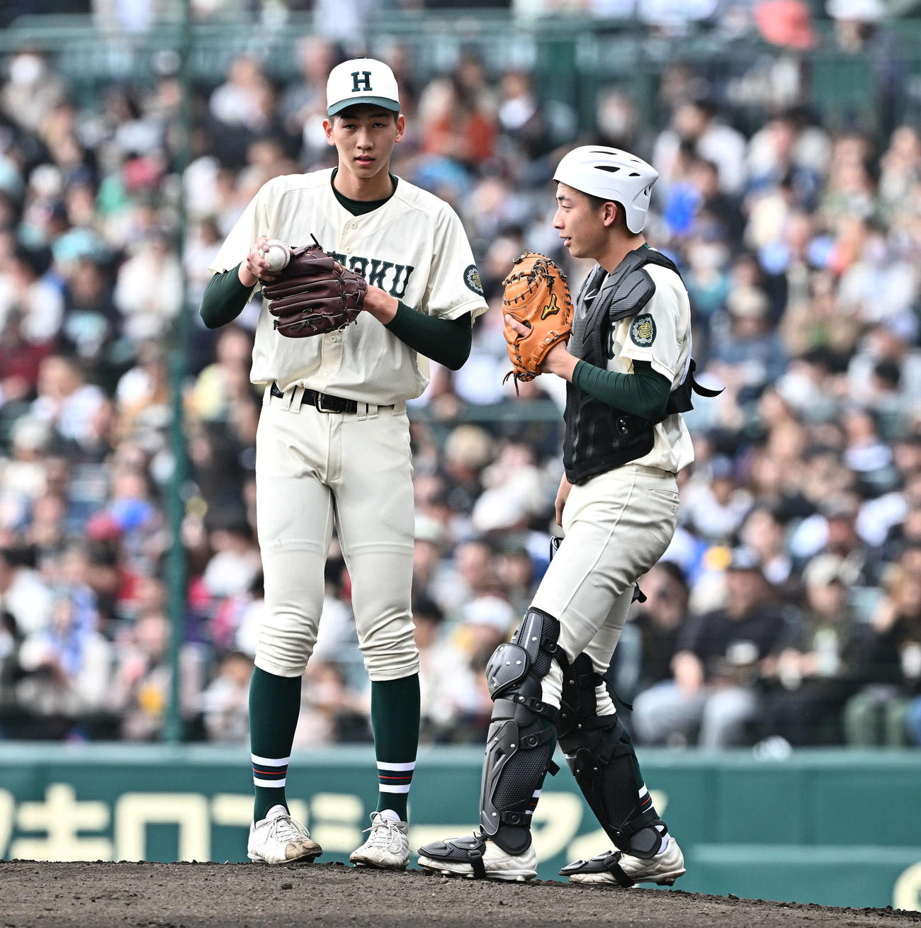 第96回選抜高校野球大会（センバツ）　11日目　決勝　報徳学園対高崎健康福祉大高崎　1回裏、マウンドで話す報徳学園・今朝丸（左）と捕手徳田（2024年3月31日撮影）