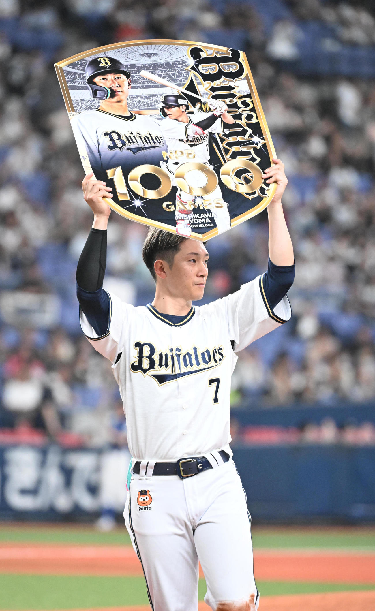 20日、1000試合出場を達成したオリックス西川龍馬はボードを掲げる