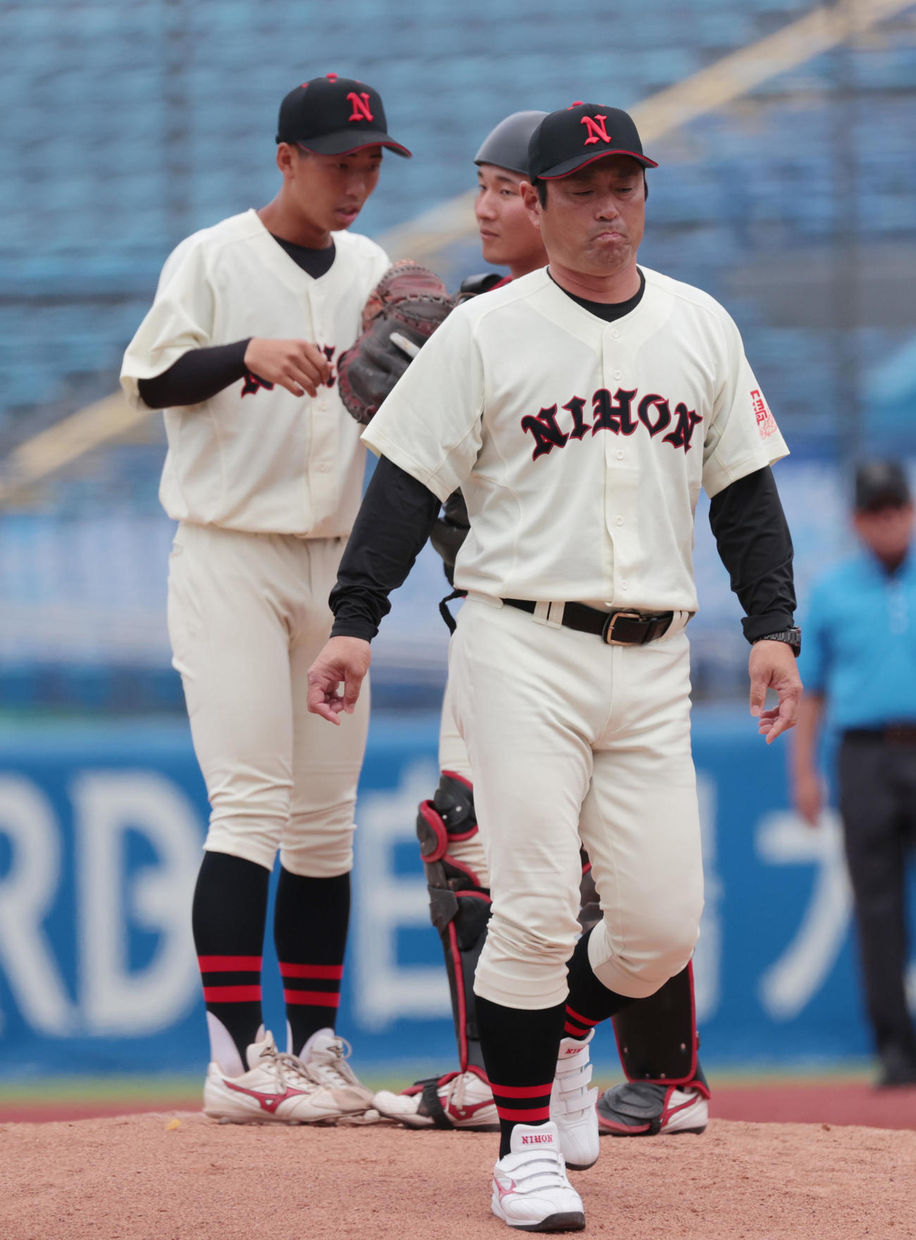 日大対亜大　2回途中で日大・菅沢から石井（左）に交代する。手前は片岡監督（撮影・柴田隆二）