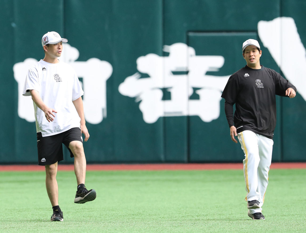 大関（左）と話をしながら体をほぐす大江（撮影・梅根麻紀）