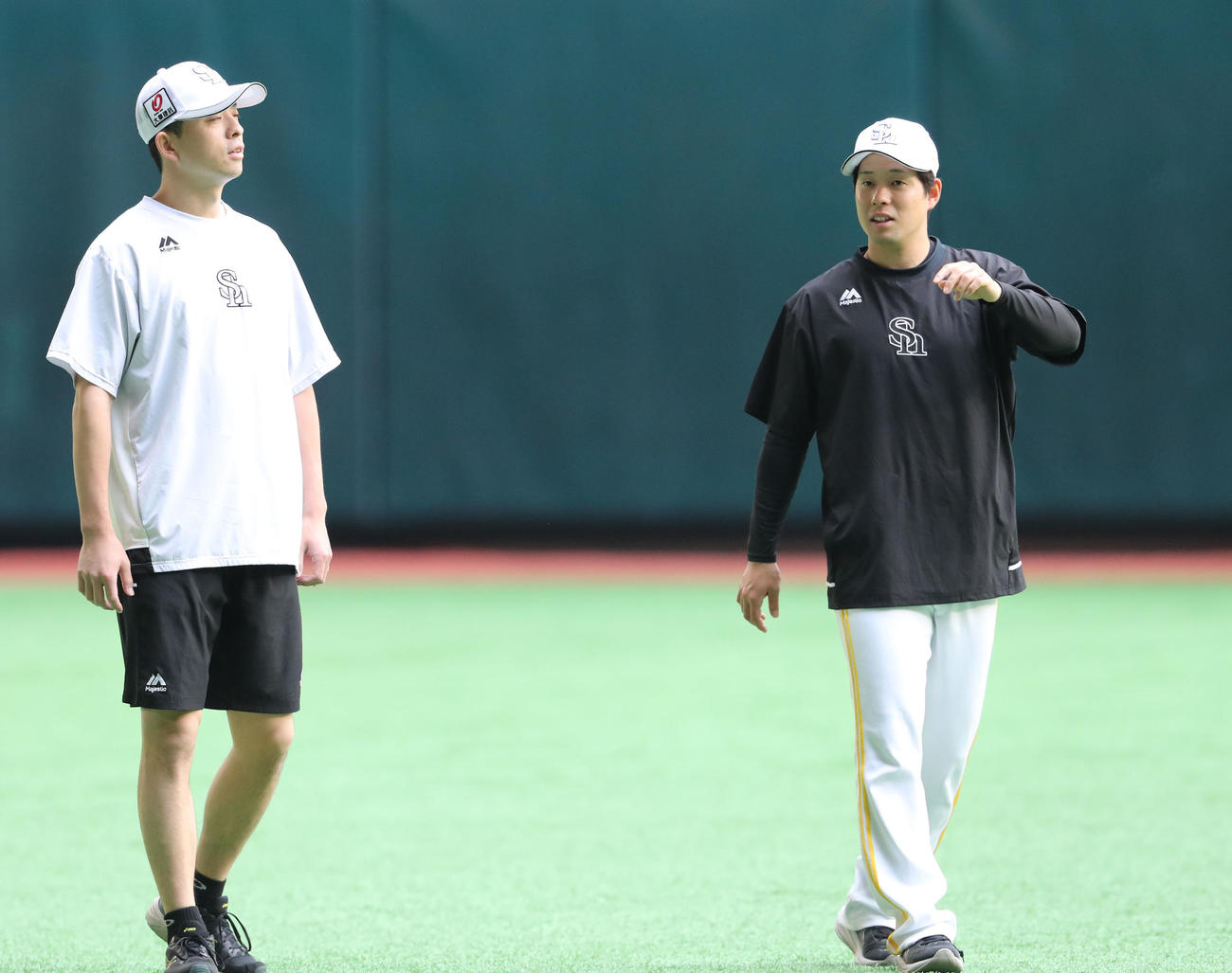 大関（左）と話をしながら体をほぐす大江（撮影・梅根麻紀）