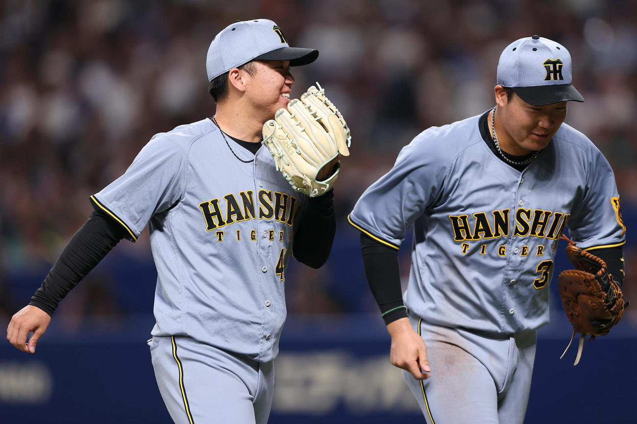 中日対阪神　4回裏を投げ終え、大山（右）と笑顔で言葉を交わす阪神村上（撮影・前田充）