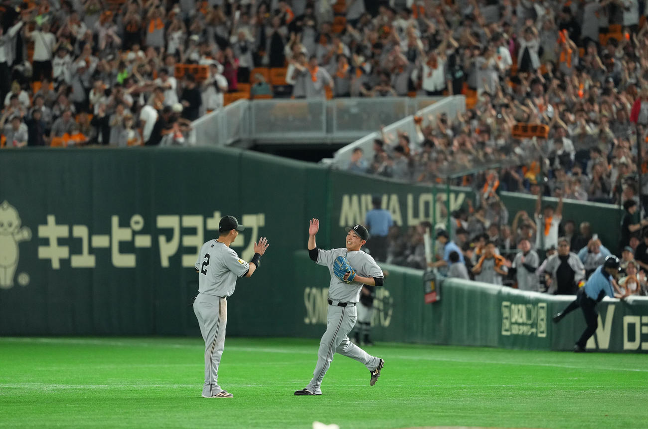 完封勝利を飾り、吉川尚（左）にタッチで祝福される巨人赤星（撮影・菅敏）