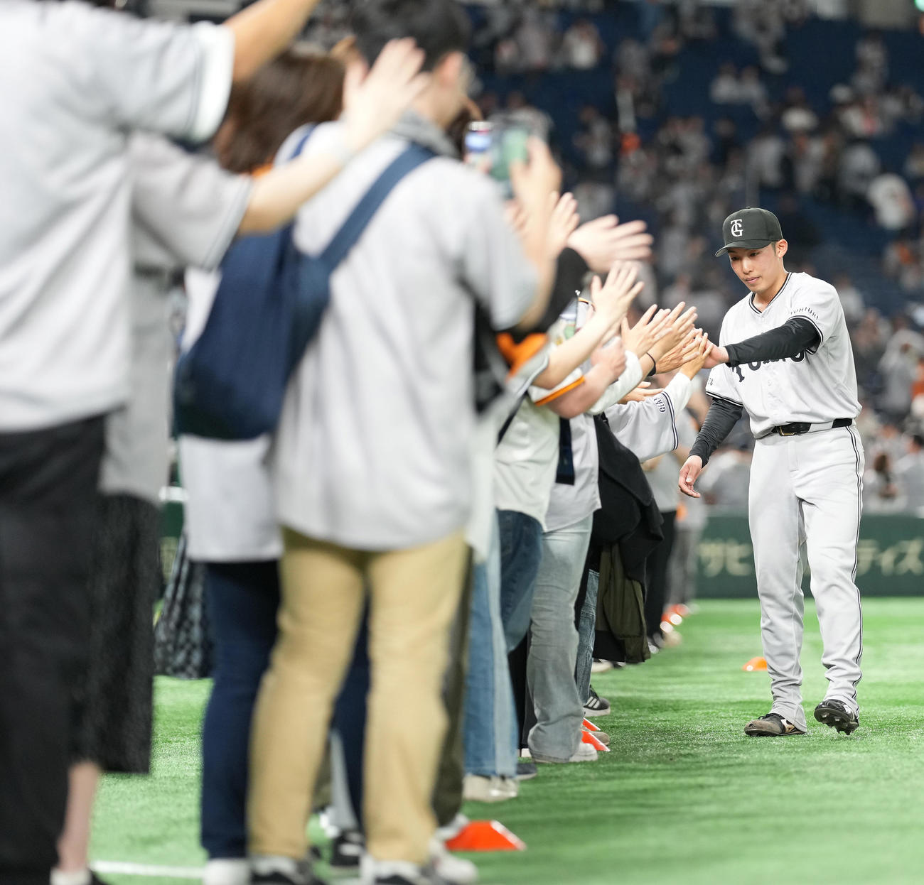 巨人対ヤクルト　完封勝利した巨人赤星（右）はファンとハイタッチ（撮影・鈴木みどり）