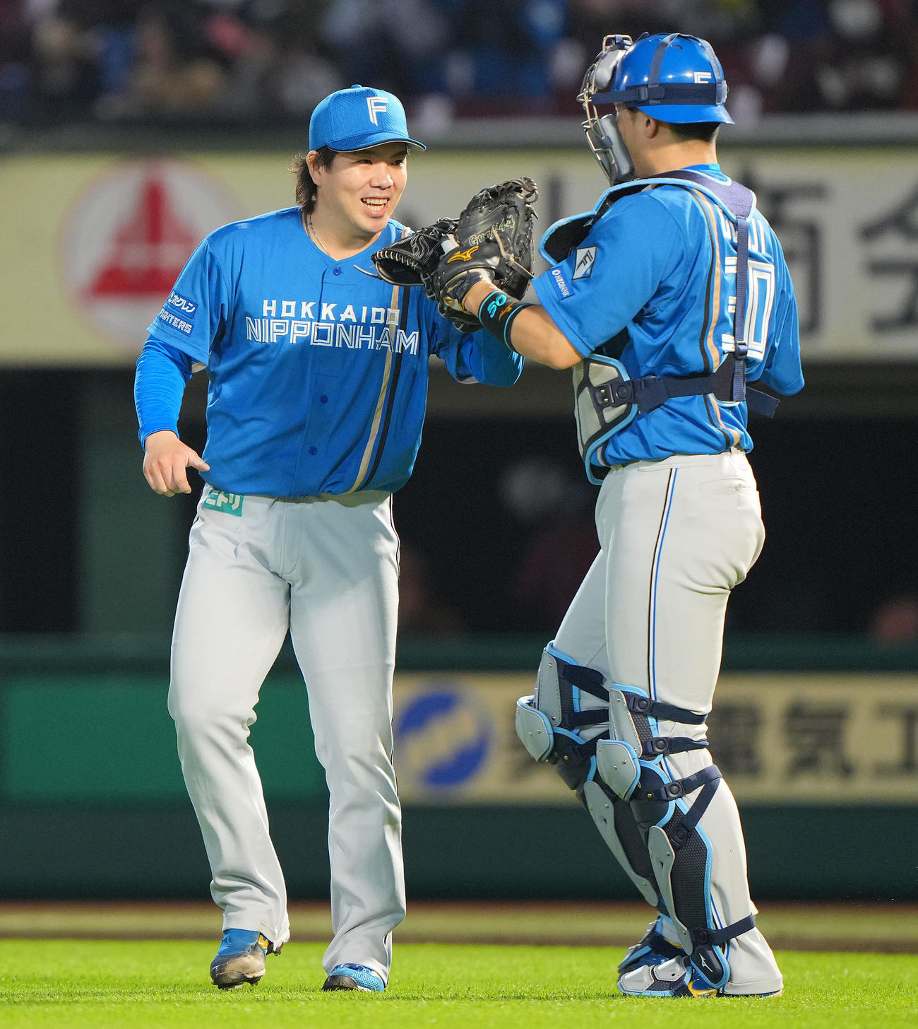 楽天対日本ハム　9回裏楽天2死、小郷を一ゴロに仕留め完封勝利の金村（左）は郡司と笑顔でタッチを交わす（撮影・垰建太）