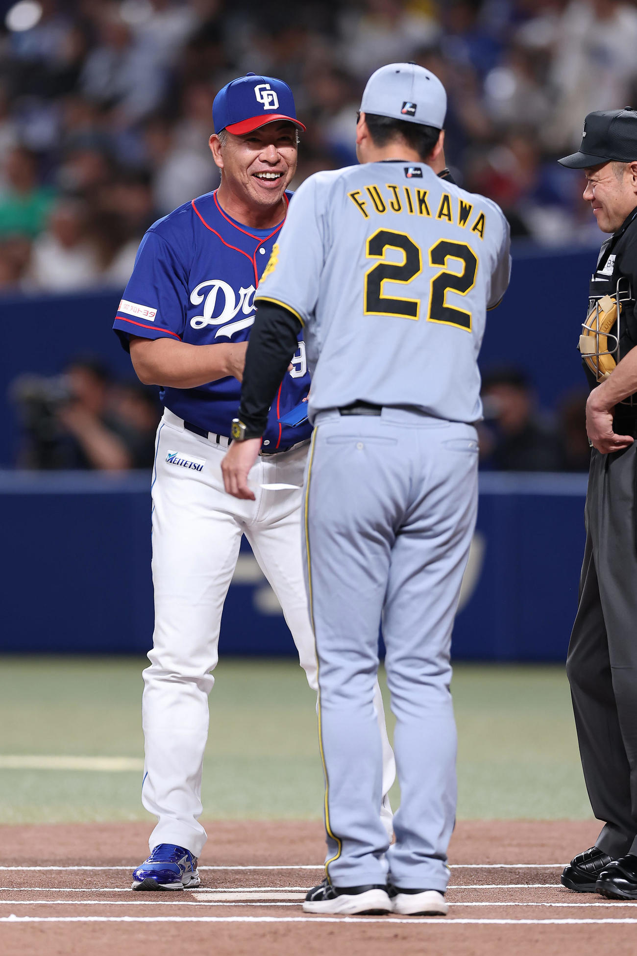 中日対阪神　試合前、笑顔を見せながら阪神藤川監督（手前）とメンバー表の交換を行う中日井上監督（撮影・前田充）