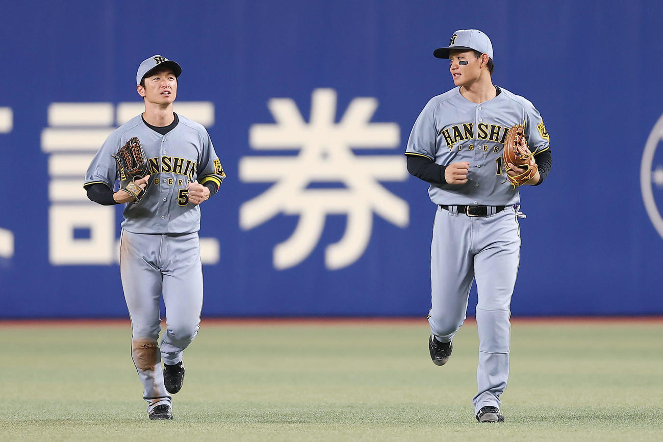 中日対阪神　中日に勝利し、言葉を交わしながらナインの輪に向かう阪神近本（左）森下（撮影・前田充）