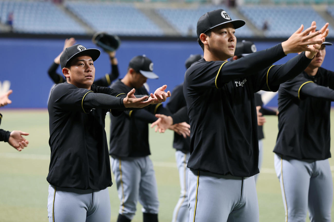 中日対阪神　ウオーミングアップを行う阪神伊原（左）と木下（撮影・前田充）