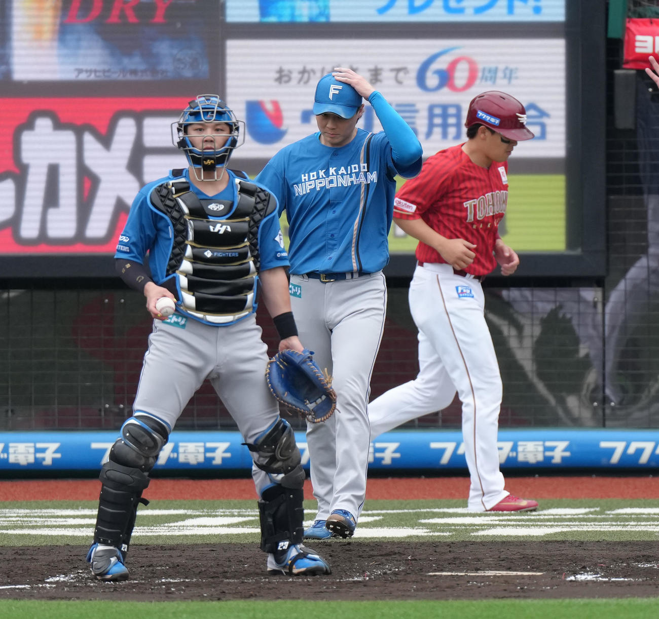 楽天対日本ハム　1回裏楽天2死満塁、宗山に中前適時打を浴び、浅村（右）の生還を許した山崎（中央）と伏見（撮影・足立雅史）