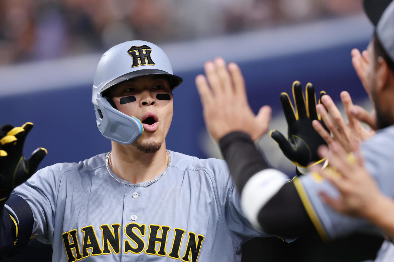 中日対阪神　2回表阪神無死、右中間へ同点本塁打を放ち、ナインに迎えられる佐藤輝（撮影・前田充）