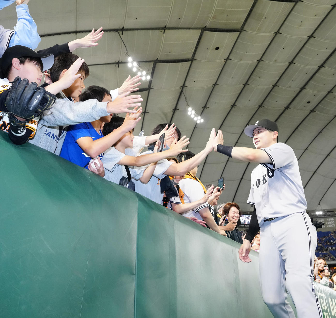 巨人対ヤクルト　試合後、ファンとタッチを交わす巨人泉口（撮影・江口和貴）