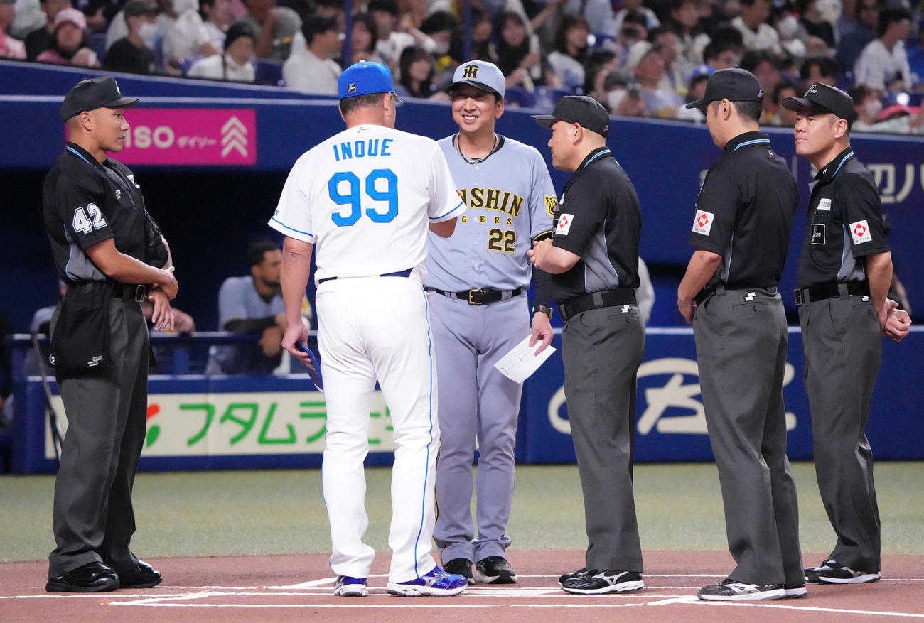 中日対阪神　メンバー表交換で審判団から話を聞く井上監督（左から2人目）と藤川監督（撮影・森本幸一）