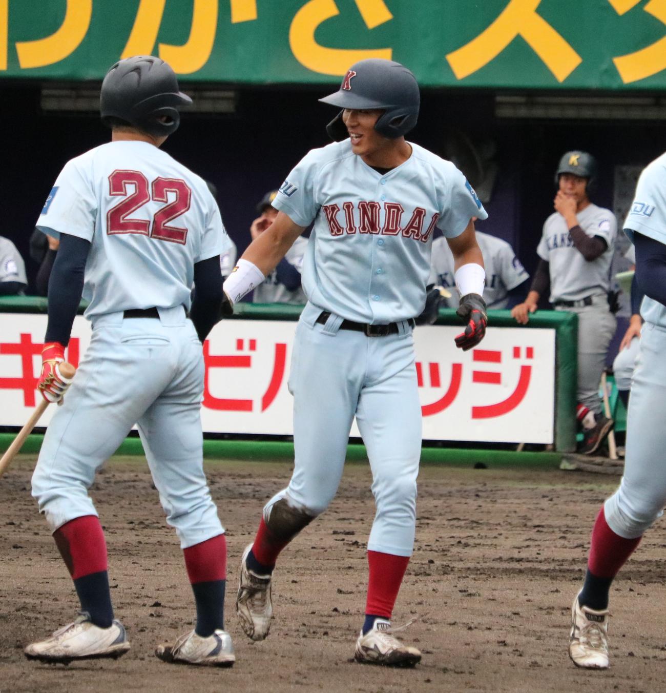 近大の野間が生還して笑顔でタッチする（撮影・林亮佑）