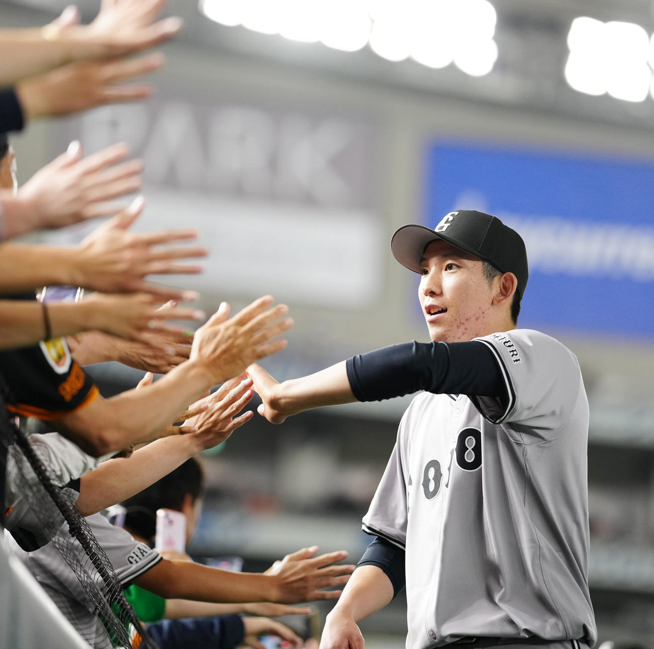 巨人対ヤクルト　試合後、ファンとタッチを交わす巨人戸郷（撮影・江口和貴）