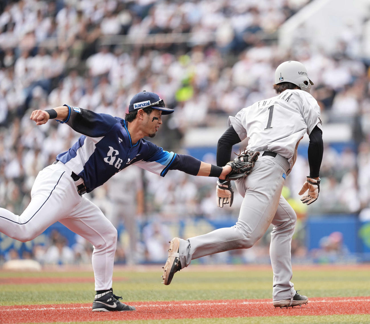 ロッテ対西武　5回裏ロッテ1死一、三塁、外崎（左）は藤原をタッチ（撮影・井上学）