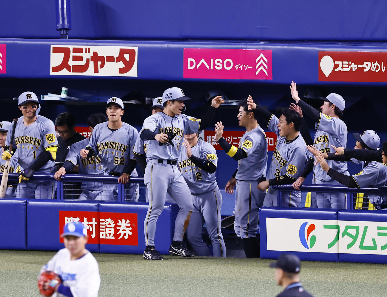 中日対阪神　9回表阪神無死二塁、相手失策で生還しナインに出迎えられる坂本本（撮影・藤尾明華）