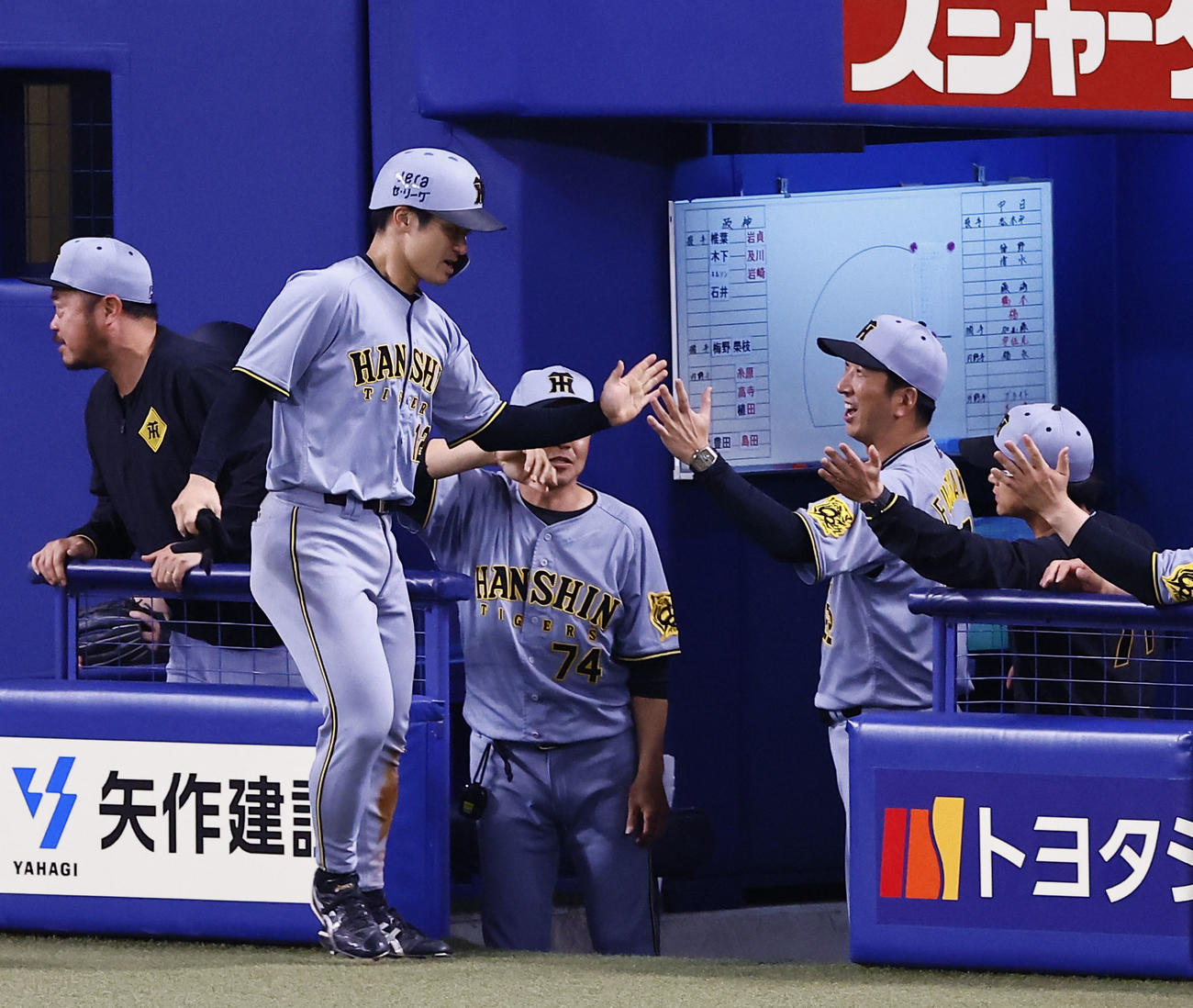 中日対阪神　9回表阪神無死二塁、相手失策で生還し藤川監督らに出迎えられる坂本（撮影・藤尾明華）