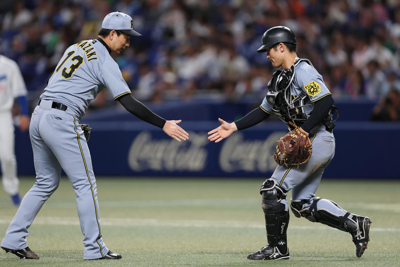 中日対阪神　中日に勝利し、握手を交わす阪神岩崎（左）と坂本（撮影・前田充）