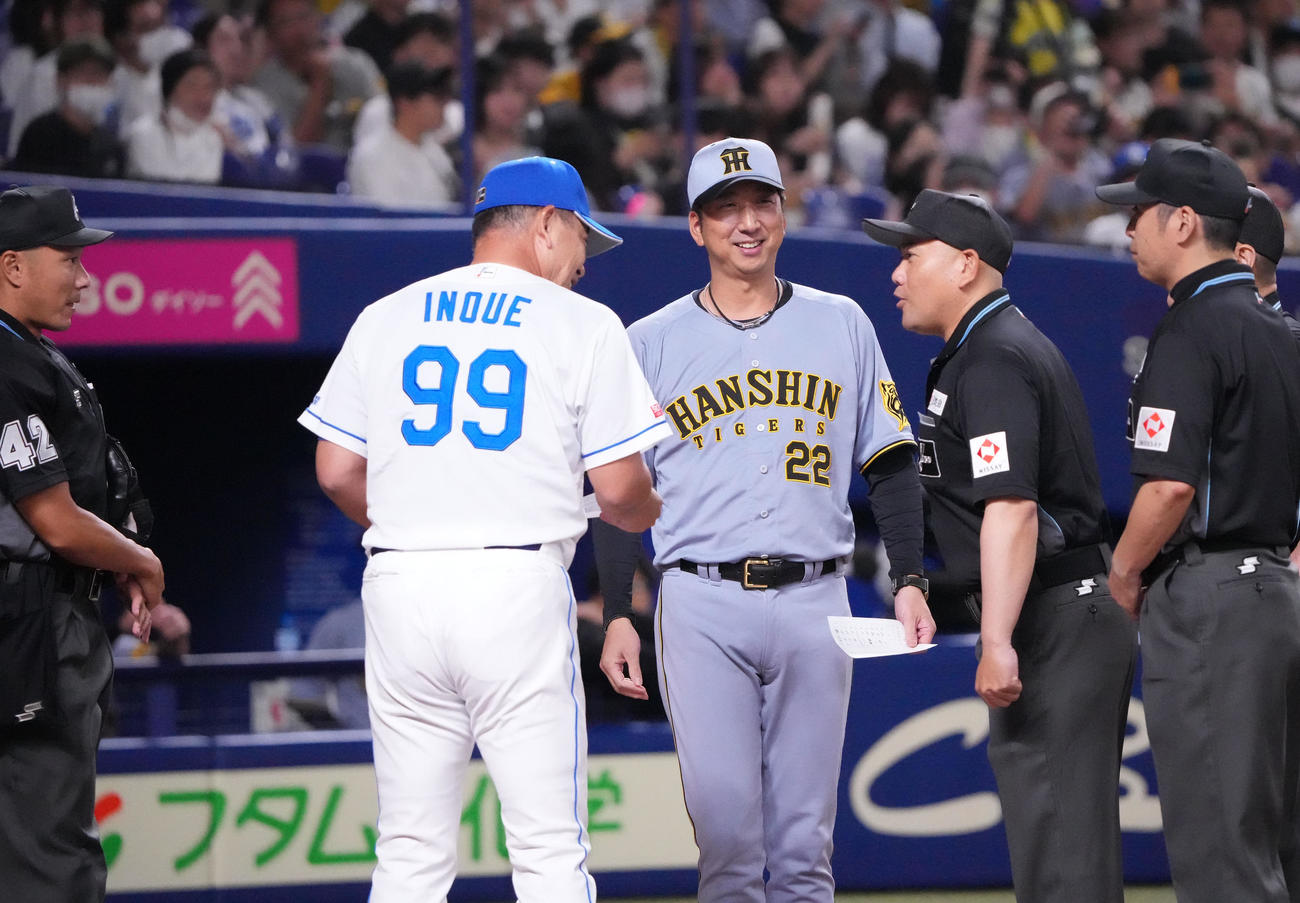 中日対阪神　メンバー表交換で審判団から話を聞く井上監督（左から2人目）と藤川監督（撮影・森本幸一）