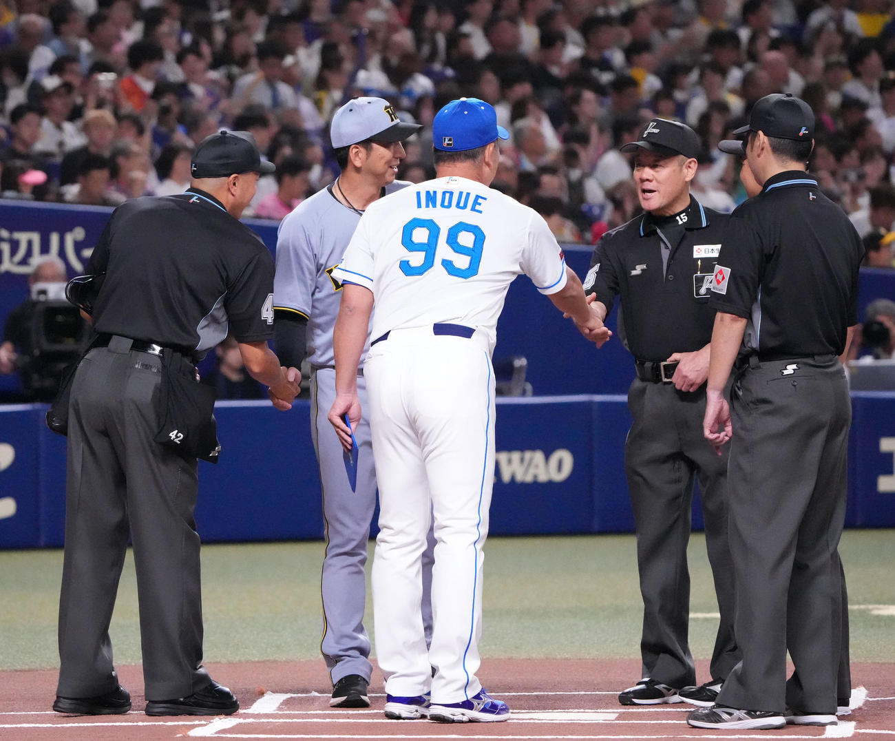 中日対阪神　メンバー表交換で審判団と握手を交わす井上監督（中央）と藤川監督（撮影・森本幸一）