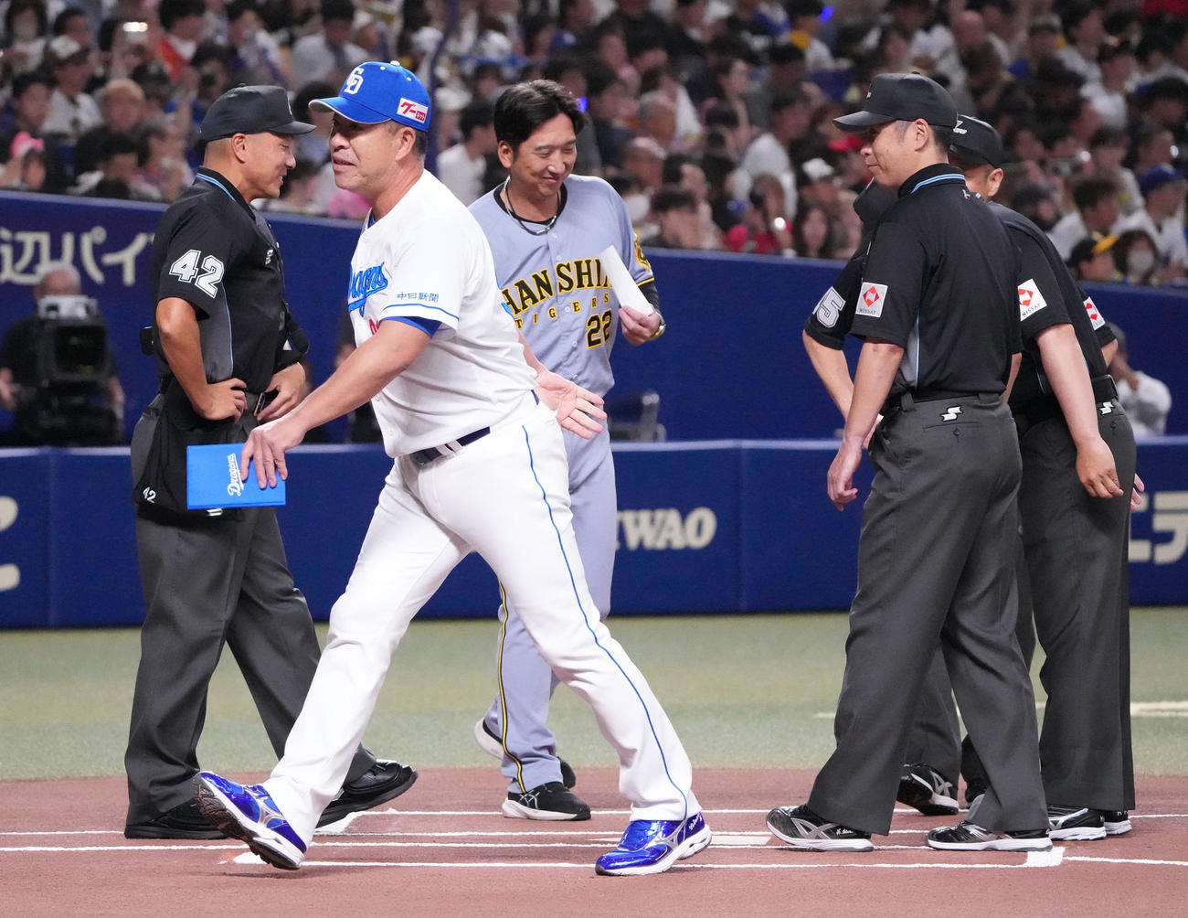 中日対阪神　メンバー表交換で審判団と握手を交わす藤川監督（中央）と井上監督（撮影・森本幸一）