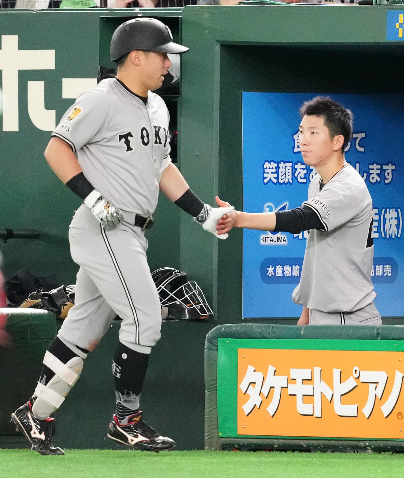巨人対ヤクルト　6回裏、送りバントを決めた巨人浅野（左）とタッチを交わす戸郷（撮影・江口和貴）