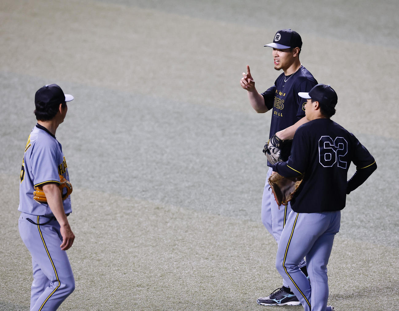 中日対阪神　左翼位置で筒井外野守備兼走塁チーフコーチ（左）と話しをする阪神佐藤輝（中央）（撮影・藤尾明華）