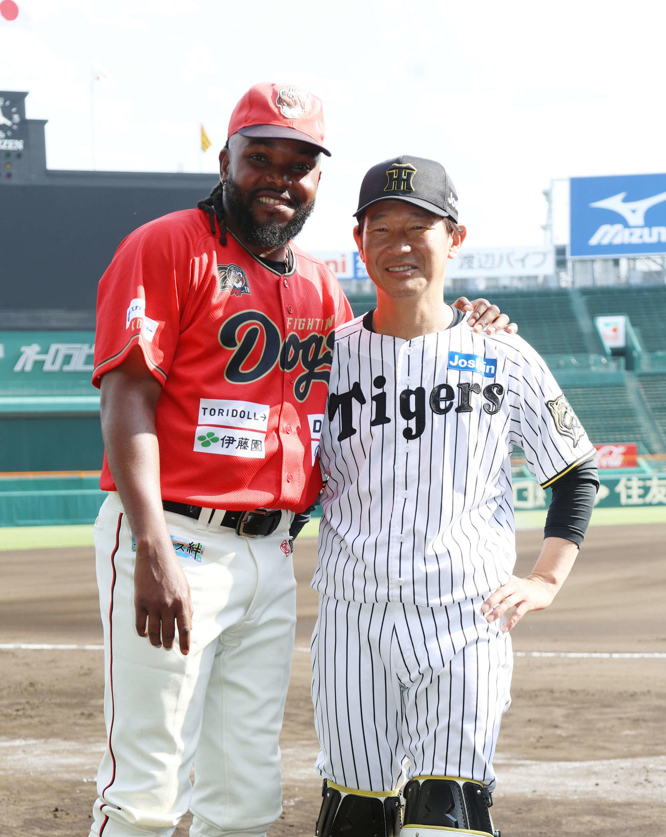 阪神対独立L連合　甲子園のマウンドに上がった阪神の元守護神、高知ドリス（左）は試合後、阪神鈴衛ブルペン捕手と旧交を温め記念写真に納まる（撮影・西尾就之）