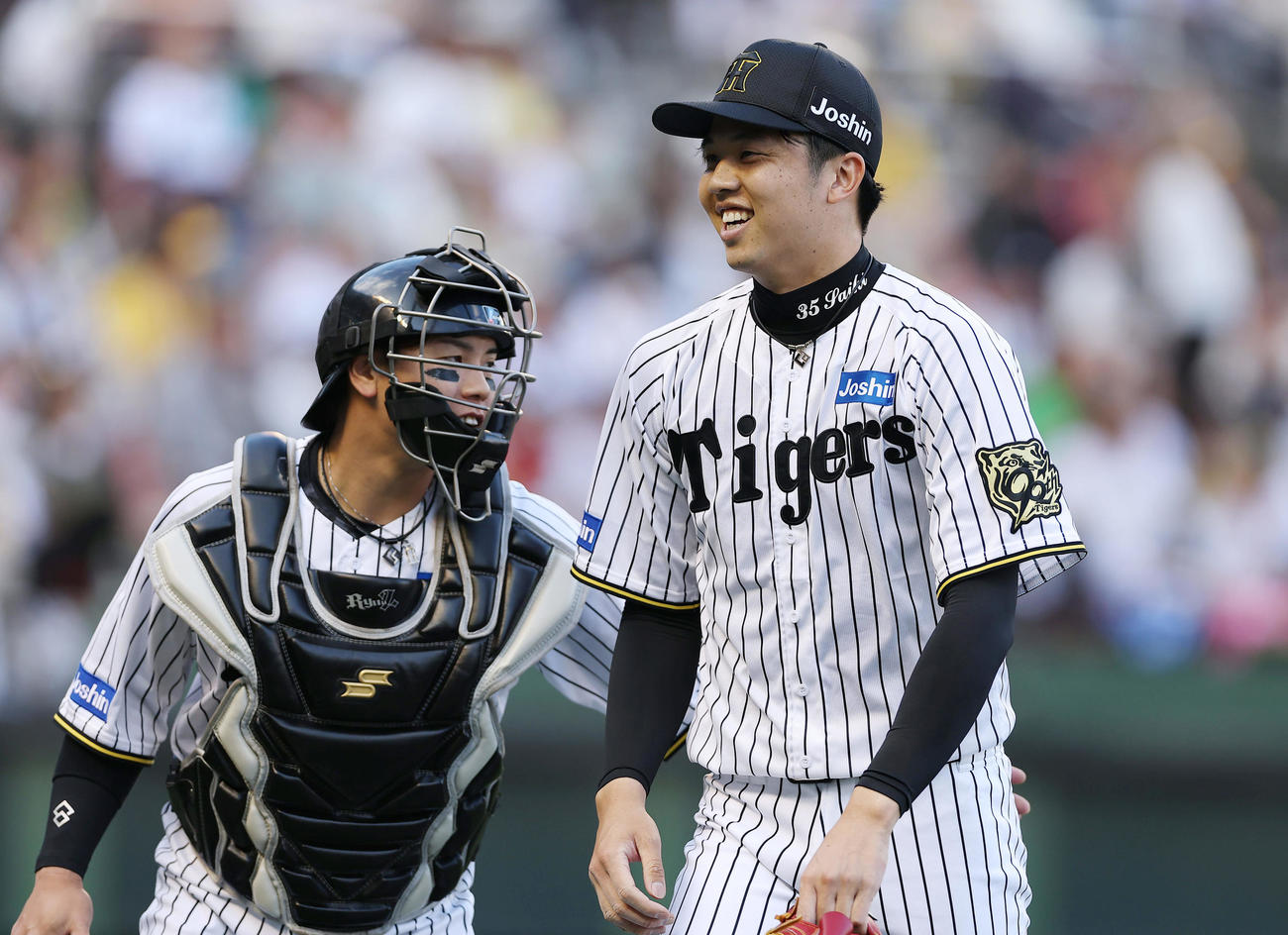 阪神対DeNA 1回表を投げ終え、笑顔を見せながらベンチへ戻る阪神才木。左は梅野（撮影・前田充）
