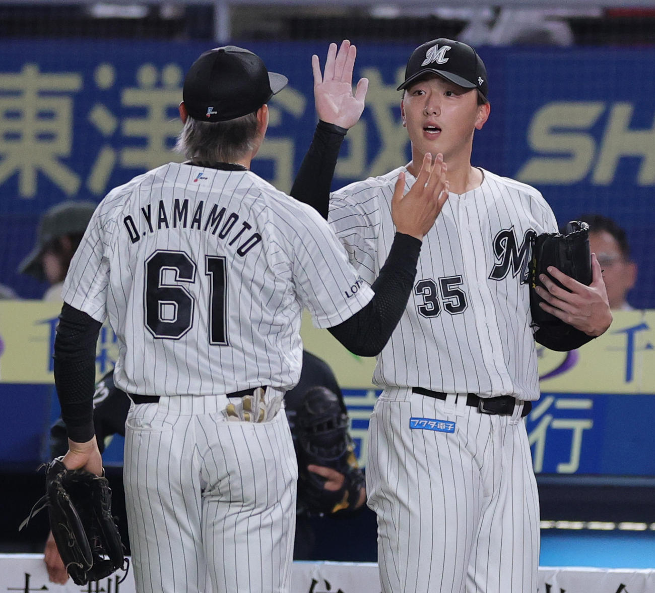 ロッテ対オリックス　7回まで無失点で山本（手前）とハイタッチするロッテ先発の田中晴（撮影・野上伸悟）