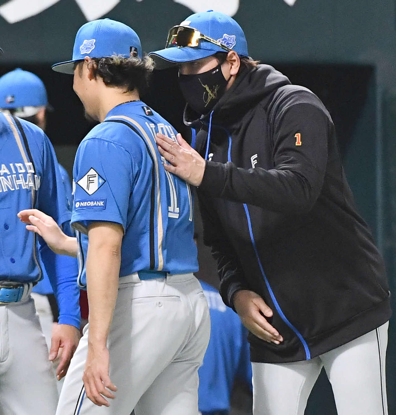 ソフトバンク対日本ハム　ソフトバンクに勝利し、今季6勝目を挙げた伊藤（左）の肩をたたく新庄監督（撮影・岩下翔太）