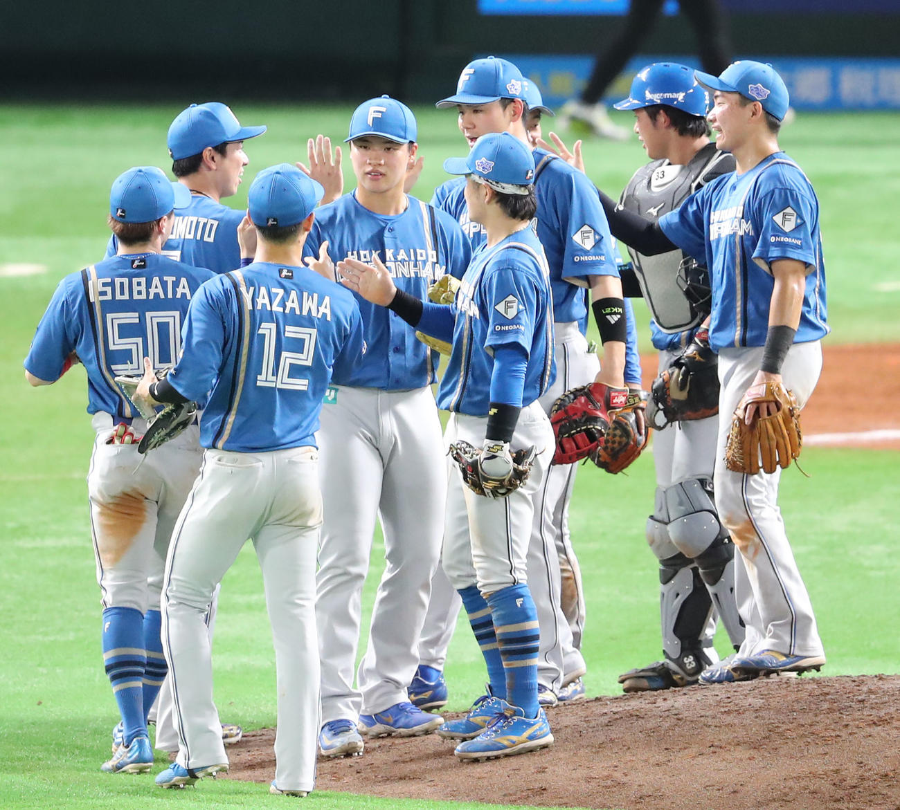 ソフトバンク対日本ハム　ソフトバンクに勝利を飾った日本ハムナインはハイタッチをかわす（撮影・梅根麻紀）