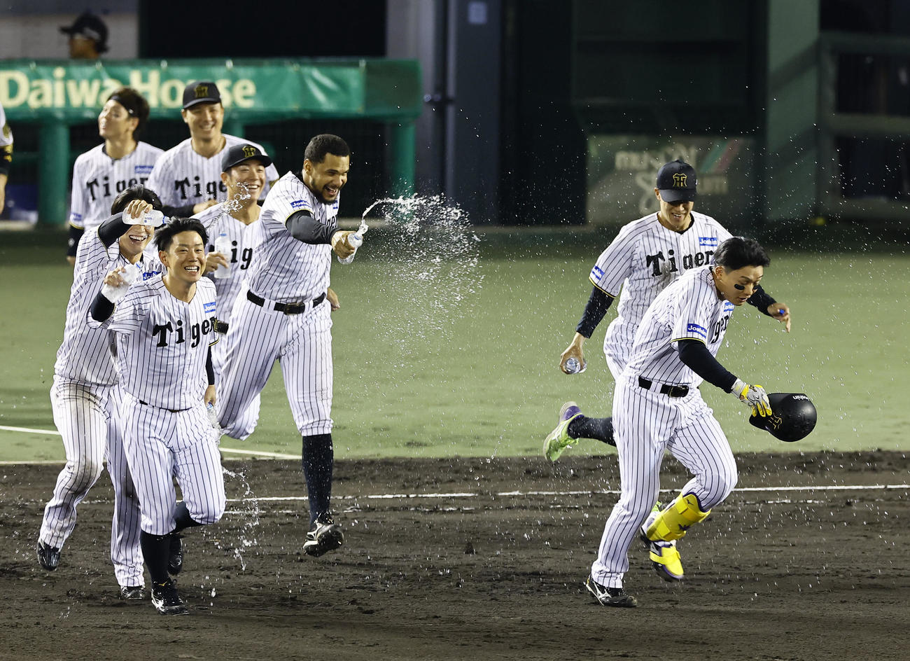 阪神対DeNA DeNAにサヨナラ勝ちし、ナインに水をかけられ祝福される阪神糸原（手前左）と森下（撮影・藤尾明華）