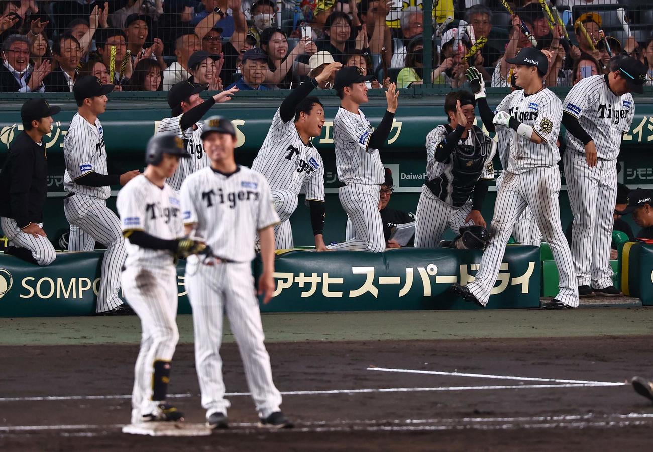 阪神対DeNA 5回裏阪神2死二塁、近本の適時打で生還した木浪（右から2人目）はナインとハイタッチをする（撮影・上田博志）