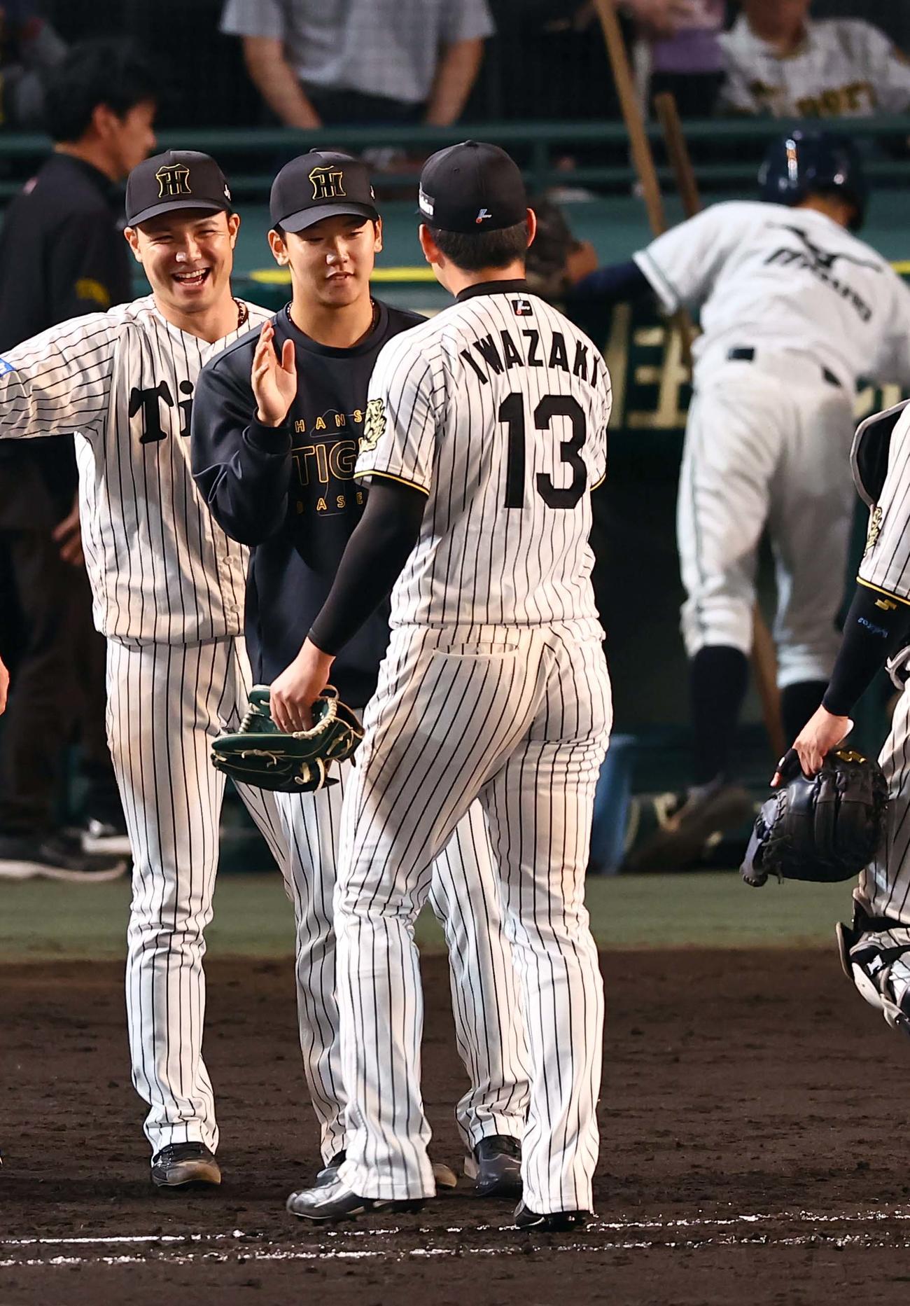 阪神対DeNA 2勝目をあげた門別（中央）は岩崎から勝利球を受け取る（撮影・上田博志）