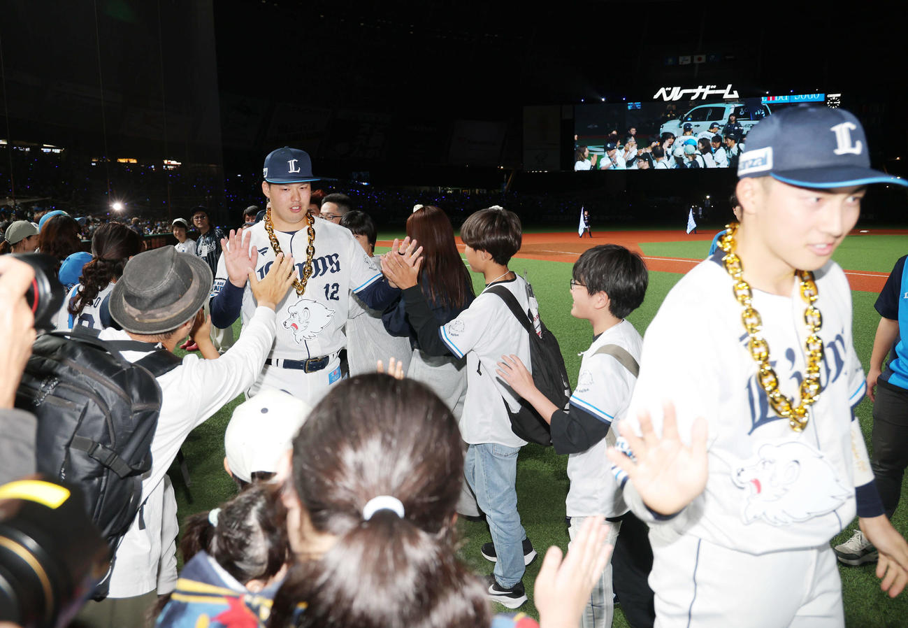 西武対楽天　楽天に勝利し、ファンとタッチを交わす西武渡辺（左）と長谷川（撮影・河田真司）