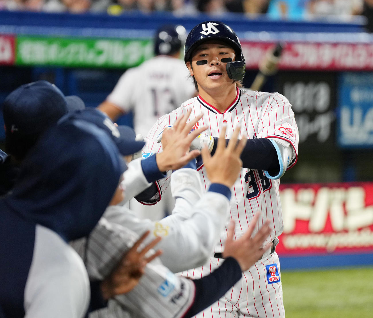 ソロ本塁打を放ちタッチで迎えられる北村拓（撮影・菅敏）