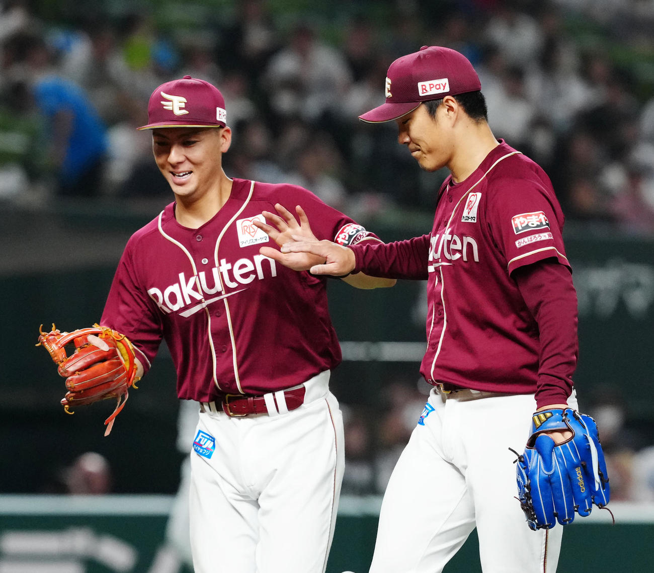 西武対楽天　6回裏終了後、楽天三塁手村林（左）とタッチを交わし、ベンチに引き揚げる3番手の則本（撮影・江口和貴）