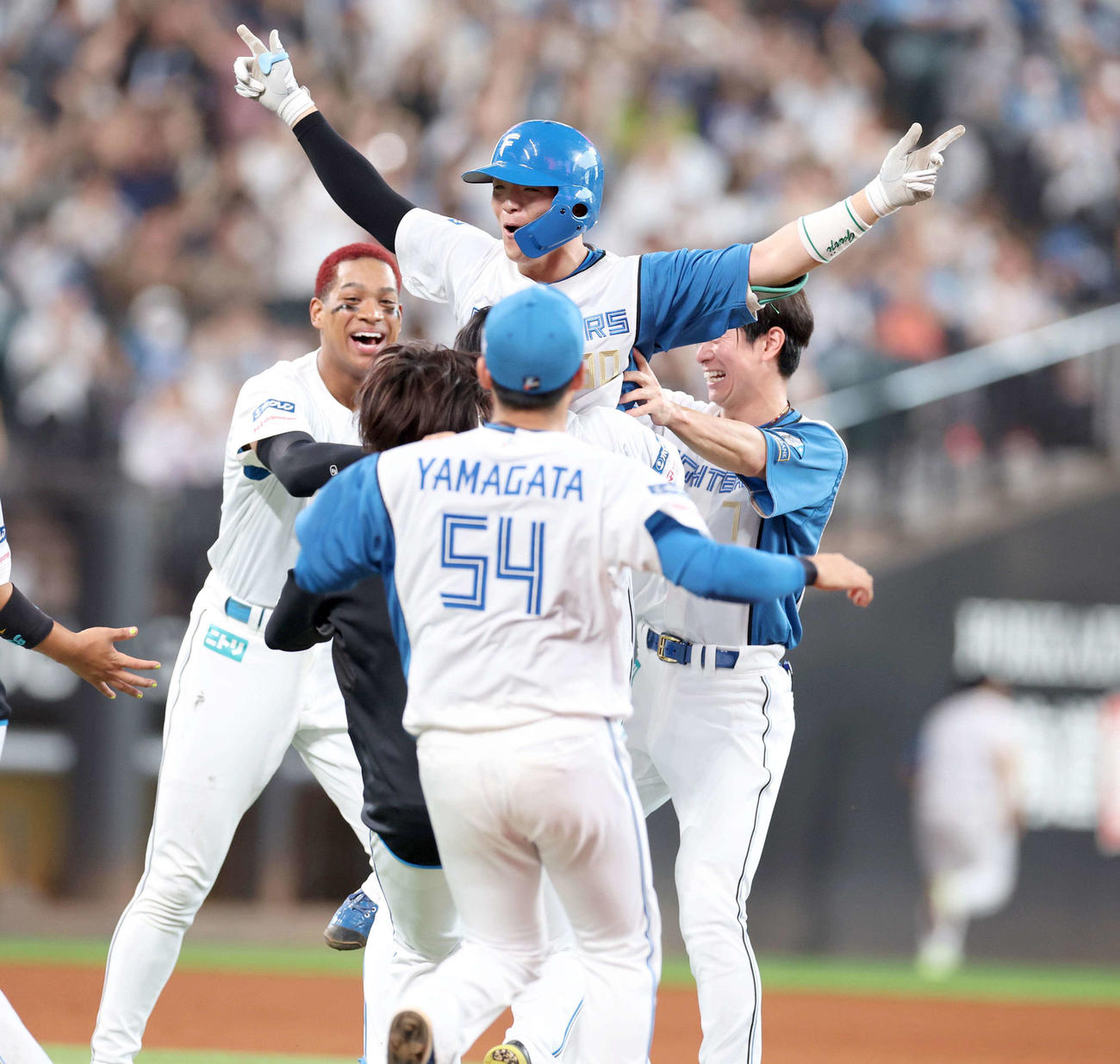日本ハム対ロッテ　9回裏、サヨナラ打を放った郡司（中央）はナインから祝福され笑顔（撮影・黒川智章）
