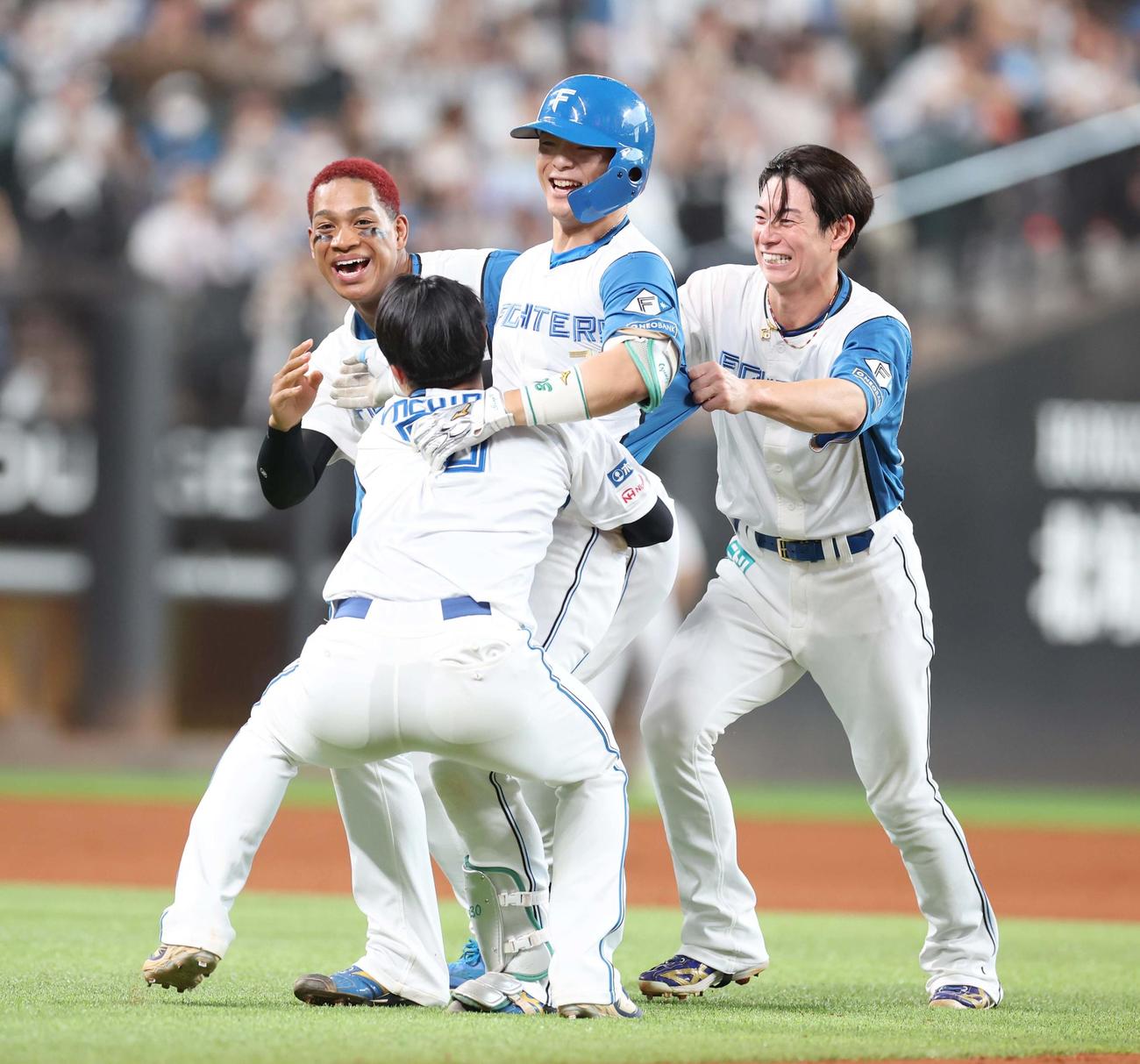 日本ハム対ロッテ　9回裏、サヨナラ打を放った郡司（中央）はナインから祝福され笑顔（撮影・黒川智章）