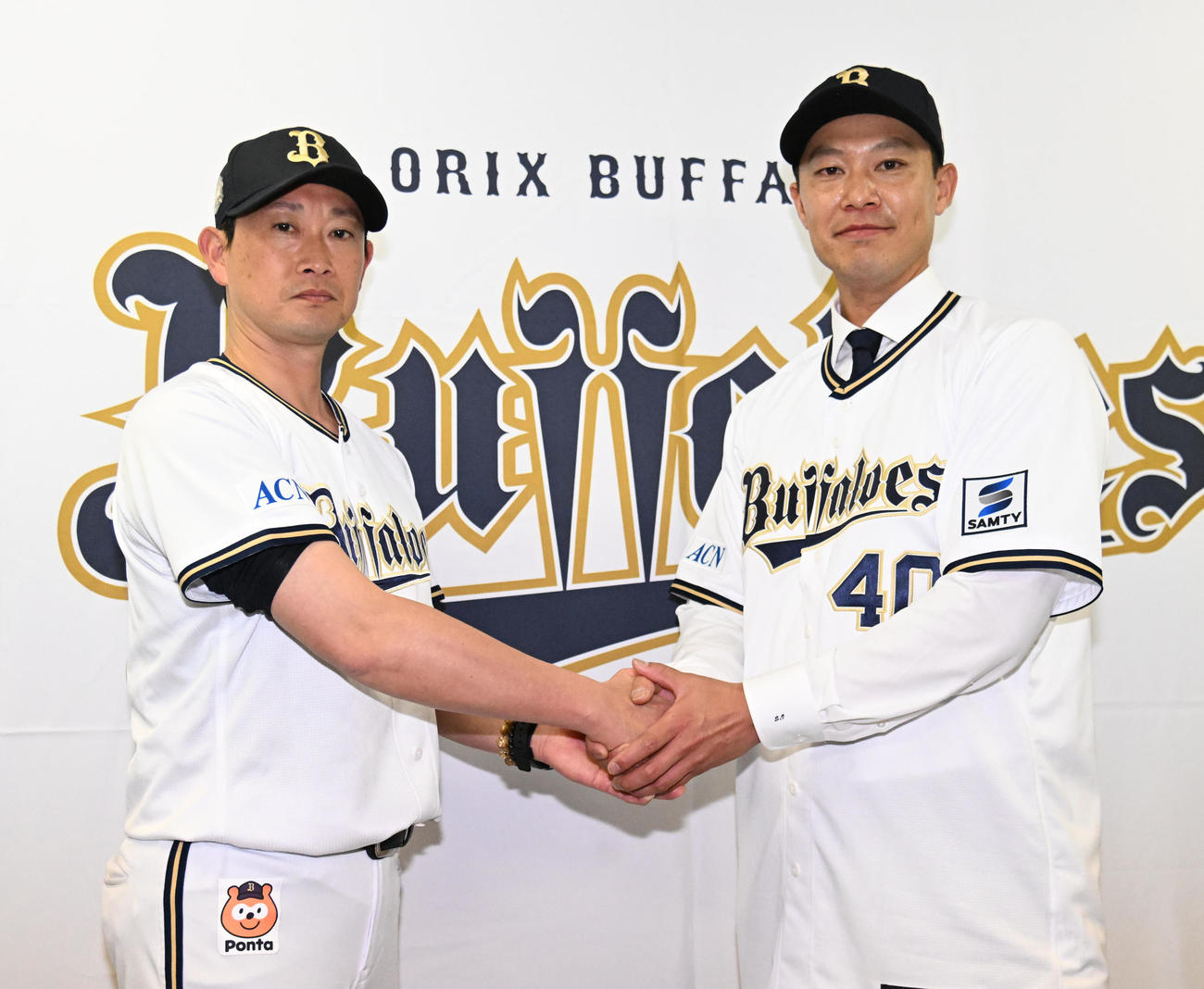 入団会見で岸田監督（左）と握手をする岩崎（撮影・石井愛子）